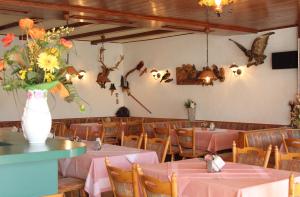ein Restaurant mit Tischen und eine Vase mit Blumen an der Wand in der Unterkunft Haus Sonnenschein in Üdersdorf