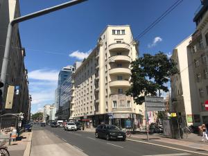 a tall white building on a city street with cars at Operastreet Residences - Big Business Apartment in Vienna