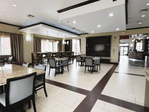 una sala da pranzo con tavoli e sedie e una TV a schermo piatto di Baymont by Wyndham Jewett a Jewett