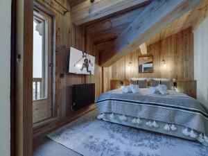 ラ・ロジエールにあるAppartement moderne avec balcon et parking à La Rosière - FR-1-690-9の木製の部屋に大型ベッドが備わるベッドルーム1室が備わります。