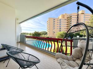 un balcon avec deux chaises et une balançoire dans l'établissement Vilamoura Marina Beach With Pool by Homing, à Vilamoura