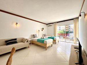 un salon avec deux lits et un canapé dans l'établissement Vilamoura Marina Beach With Pool by Homing, à Vilamoura