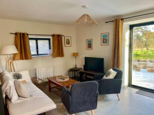 un salon avec un canapé, des chaises et une télévision dans l'établissement Ker Zélia, à Cruguel