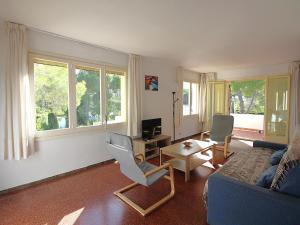 ein Wohnzimmer mit einer Couch und einem Tisch und Stühlen in der Unterkunft Casa con Jardín a 100m de la Playa de la Farella, Wifi y Garaje Privado - ES-228-175 in Llança