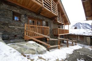 een blokhut met een veranda in de sneeuw bij A barma drola in Brusson +13 foto's