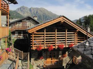 een blokhut met bloemen aan de voorkant bij A barma drola in Brusson