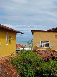 a yellow building with the ocean in the background at Pousada Fonte da Samaritana in Vila Velha +20 photos