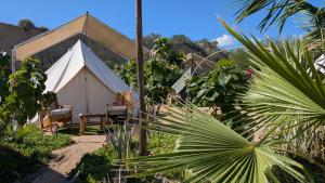 una tienda de campaña con una mesa y un banco en un jardín en La Window Glamping, en La Ventana