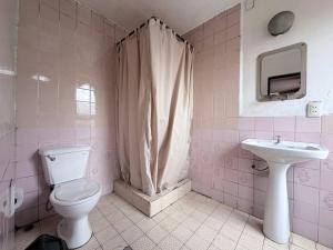 Baño de color rosa con aseo y lavamanos en Hostal Tambo de Oro, en La Paz 35 fotos más