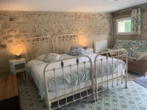 ein Schlafzimmer mit einem Bett und einer Couch in der Unterkunft Petit gîte à la ferme des buttons in Rosnay