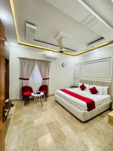 a bedroom with a bed and a table and chairs at Holiday One Hotel & Suites - Gulshan-4 in Karachi +75 photos