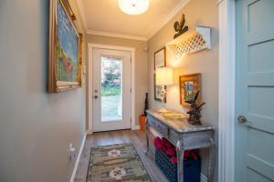 einen Flur mit einer Tür und einem Tisch mit einer Lampe in der Unterkunft Ocean Dream Beach House in Saint Peters + 35 Fotos