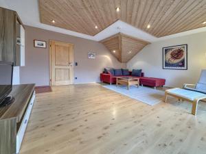 a living room with red couches and a wooden ceiling at Riedenburg I in Buch