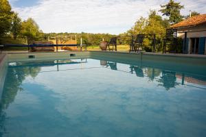 a swimming pool with blue water in a yard at Le Patio Bleu in Saint-Romain