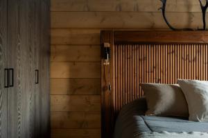une chambre avec des murs en bois et un lit avec des oreillers dans l'établissement Saana's chalets Levi, à Levi