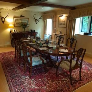 una sala da pranzo con tavolo e sedie su un tappeto di Finstock Manor a Finstock Altre 19 foto