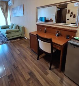 Cette chambre comprend un bureau avec une chaise et un canapé. dans l'établissement Silver Marina Apartment-Őrzött mélygarázs, à Balatonfüred