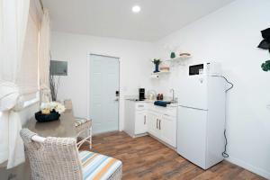 eine Küche mit einem weißen Kühlschrank und einem Tisch in der Unterkunft Rio retreat - Unit B in Miami