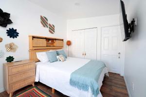 ein Schlafzimmer mit einem weißen Bett und einer Kommode und einem Bett sidx sidx sidx in der Unterkunft Rio retreat - Unit B in Miami