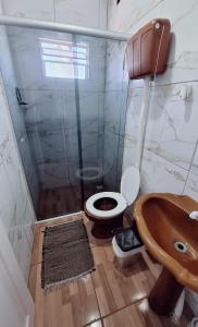 ein Badezimmer mit Toilette und Waschbecken in der Unterkunft KITNET S4 em TORRES-RS - Confortável com cama casal box, cama de solteiro bicama, televisão, geladeira, micro-ondas, chaleira elétrica, ar-condicionado split - Anfitriã Superhost no BnB in Torres