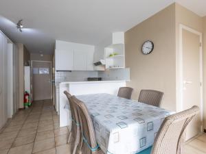 une table à manger avec des chaises et une horloge murale dans l'établissement Green Garden blok 1 - 0105, à Miami Wijk 2 autres photos