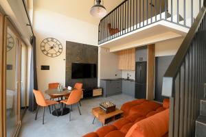 a living room with an orange couch and a table at Górskie Kąty Resort Michałkowa in Michałkowa
