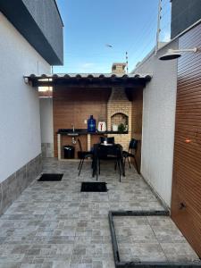 eine Terrasse mit Tisch und Stühlen in einem Gebäude in der Unterkunft Casa dos Ventos countrym climate and sea breeze in Cabo Frio