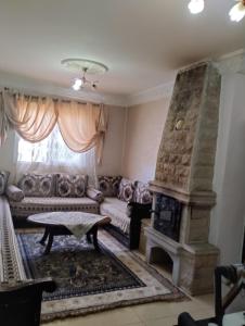 a living room with a couch and a fireplace at maison soleil in Ifrane