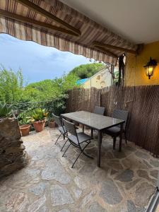 eine Terrasse mit Tisch und Stühlen und einem Zaun in der Unterkunft Cozy apartment in Bormes-les-Mimosas