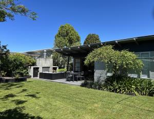ein Haus mit einem Rasen davor in der Unterkunft Stephens Bay Delight Kaiteriteri in Kaiteriteri