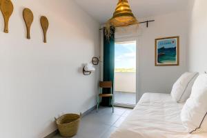 阿格德角L'horizon T4 vue mer rooftop balcon garages的一间卧室，有一张白色的床和一扇窗户