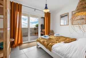 阿格德角L'horizon T4 vue mer rooftop balcon garages的一间卧室，里面有一张床和一扇大窗户。