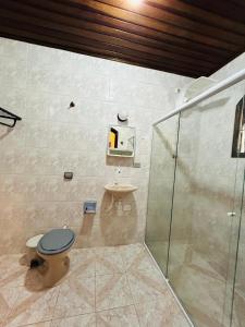 a bathroom with a toilet and a shower at Pousada Valle do Sol in Campos do Jordão