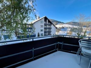 a chair sitting on the balcony of a building at Goldener Hahn B&B Baiersbronn - Ferienwohnungen mit Hygge Pool & Sauna in Baiersbronn