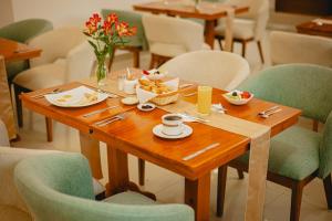 a wooden table with plates and bowls of food on it at Hotel LaJoya in Otavalo