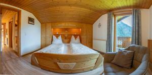 a bedroom with a large bed in a wooden room at Ferienwohnungen Niederarnigerhof Familie Bauernfeind in Kals am Großglockner