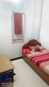 Un dormitorio con una cama, un espejo y una mesa. en Suriya Inn, en Tiruchchirāppalli 2 fotos más