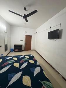 Una habitación con una cama y un televisor de pantalla plana. en Suriya Inn, en Tiruchchirāppalli