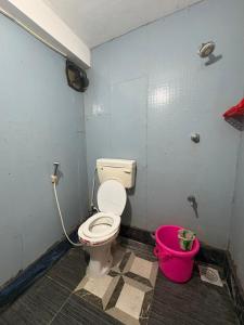 Un baño con inodoro y un cubo rosa. en Suriya Inn, en Tiruchchirāppalli