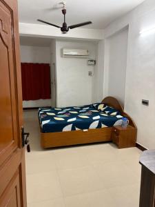 Un dormitorio con una cama y un ventilador de techo. en Suriya Inn, en Tiruchchirāppalli
