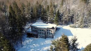 - une vue aérienne sur une maison dans la neige dans l'établissement Modern Waterfront Cottage on the Rouge River & Spa, à Rivière-Rouge