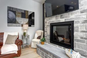 Il comprend un salon doté d'une cheminée et d'une télévision à écran plat. dans l'établissement Modern Waterfront Cottage on the Rouge River & Spa, à Rivière-Rouge 28 autres photos