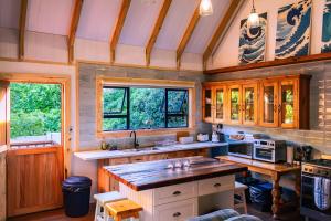 a kitchen with wooden cabinets and a large island at Magical Cabin in the Woods in Kleinbaai