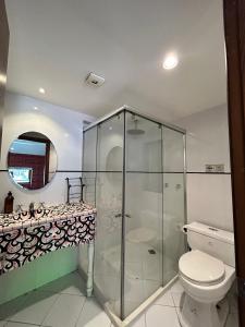une salle de bain avec une douche en verre et des toilettes dans l'établissement Villa Ana María Cuenca-Hotel, à Chaullamba