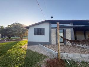 a house with a hammock in front of it at Gran Luha Motel, Hotel in Brotas