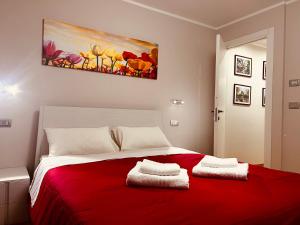 Un dormitorio con una cama roja con una pintura en la pared en La Rose du Prevot, en Fenis