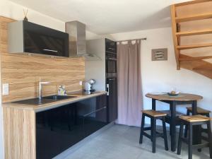 a kitchen with a sink and a counter with stools at Charmante maison rénovée au calme avec jardin privatif, à 500m des plages et proche commerces - FR-1-306-1082 in Batz-sur-Mer +25 photos