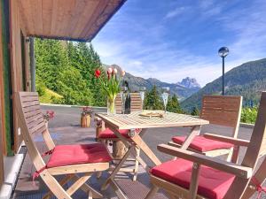 a wooden table and chairs on a patio with a view at Chalet Sole delle Dolomiti in Varda