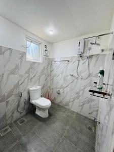 a white bathroom with a toilet and a shower at Freedom Peak Cabin Ambewela in Nuwara Eliya