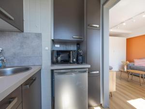 une cuisine avec un évier et un micro-ondes dans l'établissement Carla - 0801B, à Miami Wijk
